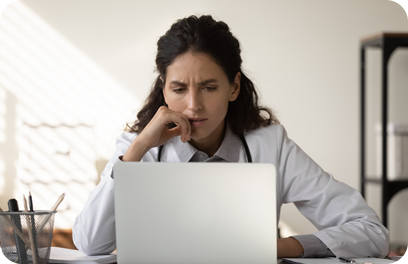 Pensive young female GP or physician in white medical uniform look at laptop screen thinking or pondering. Thoughtful woman doctor make decision or have problem working on computer in hospital.