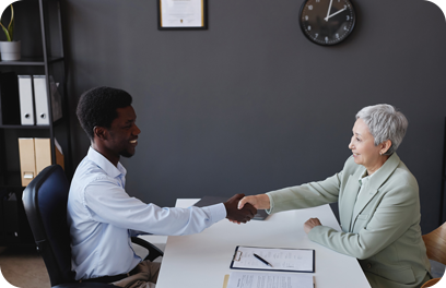 Side view portrait of smiling senior woman shaking hands with employer at job interview