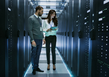 :Female and Male IT Engineers Discussing Technical Details in a Working Data Center/ Server Room