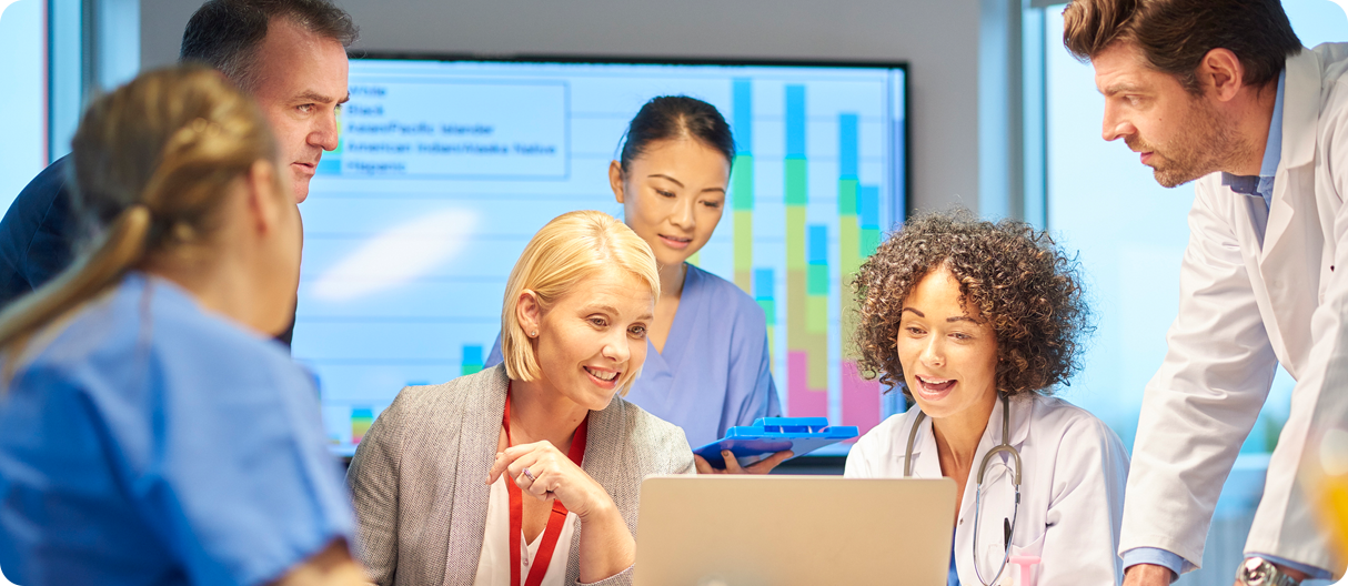 a mixed group of healthcare professional and business people meet around a conference table .