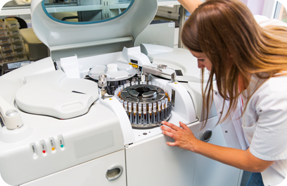 Scene from a blood bank...Young Woman Lab scientist placing test tubes with blood samples in a centrifuge