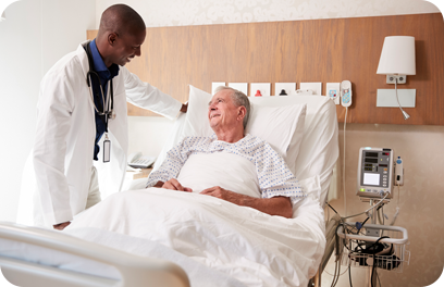 Doctor Visiting And Talking With Senior Male Patient In Hospital Bed