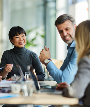 Group of happy multiracial entrepreneurs communicating during a meeting in the office. Focus is on Japanese woman.