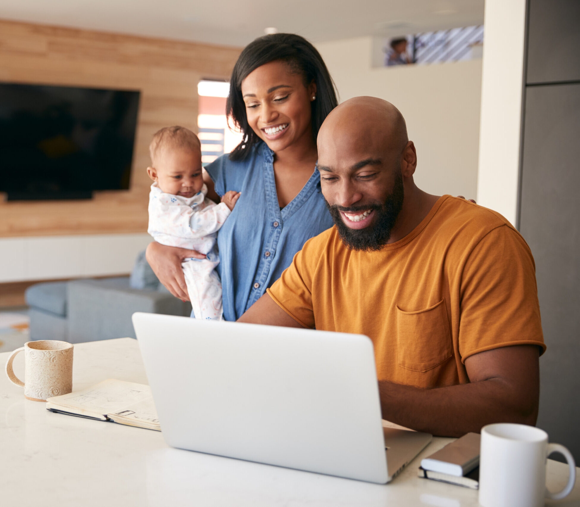 African American Family With Baby Daughter Using Laptop To Work From Home